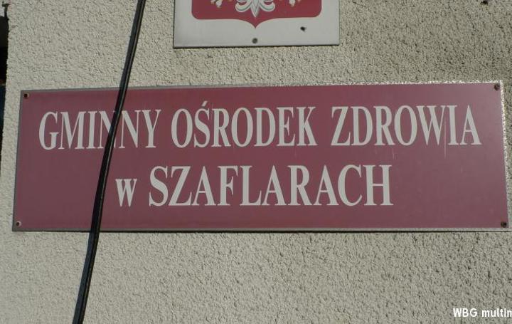 Czerwona tablica z nazwą: Gminny Ośrodek Zdrowia w Szaflarach
